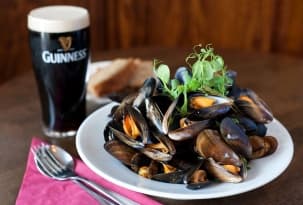 Bowl of fresh mussels served with a pint of Guinness