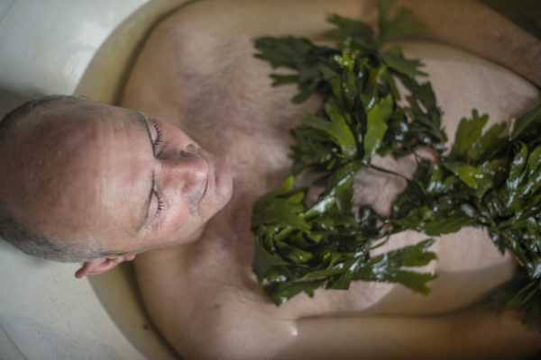 Senior man relaxing in a seaweed bath in Sligo, Ireland.
