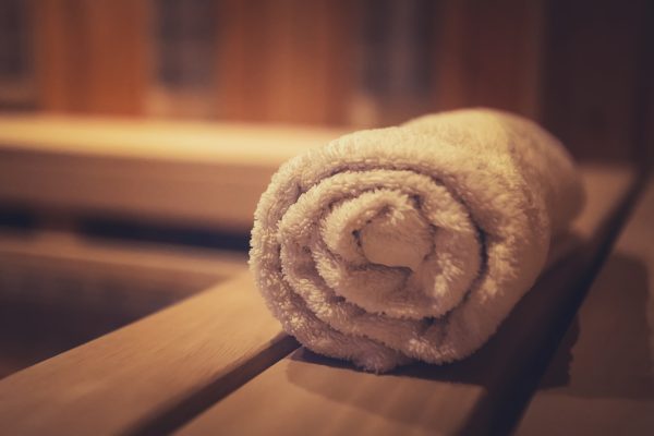 A close up of a soft terry bath towel in a wooden steam sauna. Comfortable rest in a traditional Russian cedar bath. Execellent conviniences for relaxation in steam room of eco-designed sauna